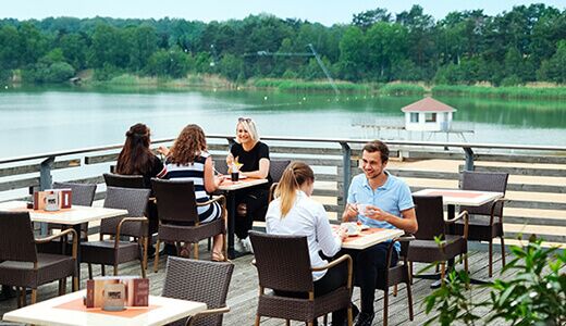 Gäste dinieren auf der Seeterrasse