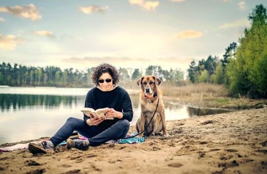 Frau mit Hund am Hundestrand